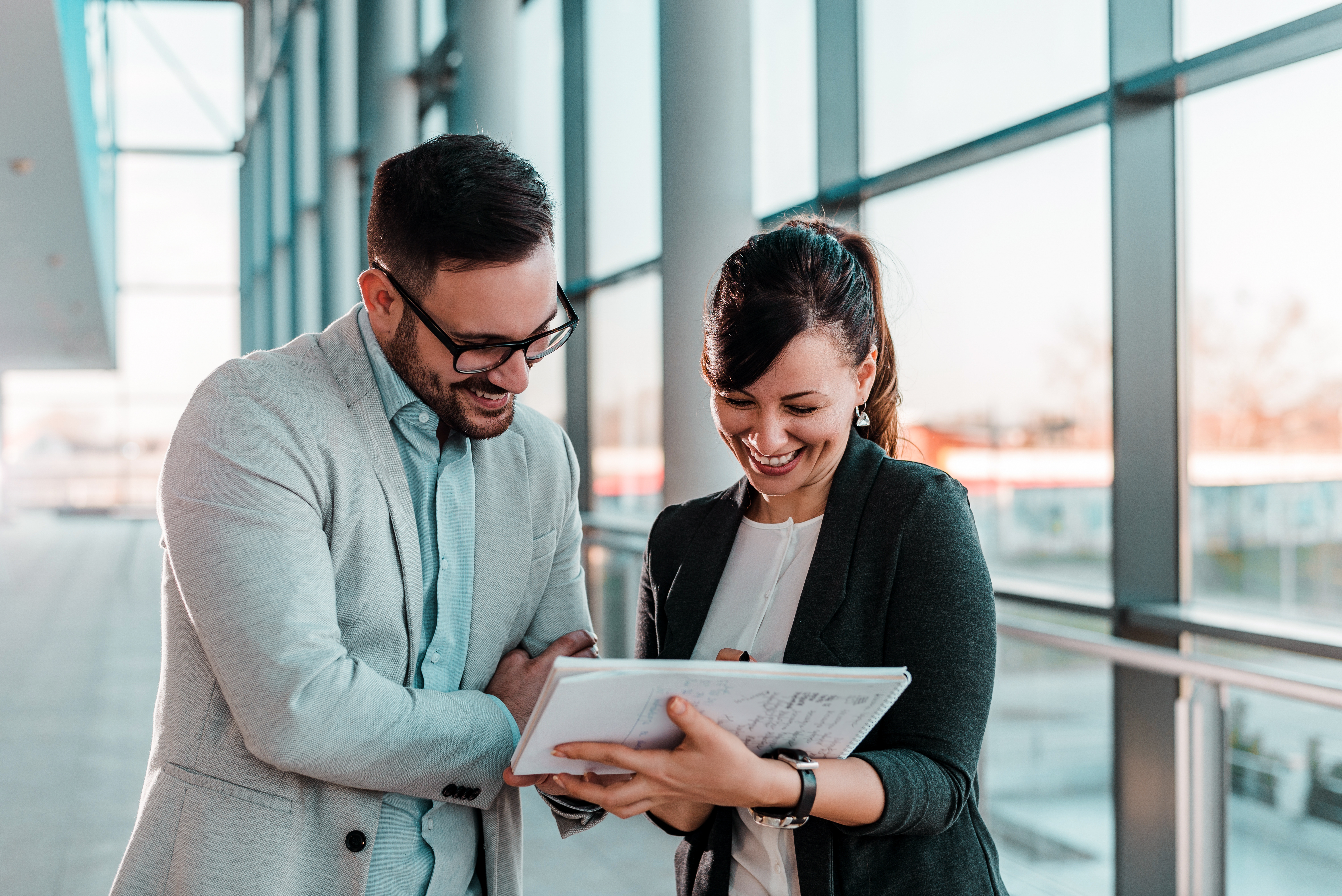 A picture of a man and woman discussing something over an ipad